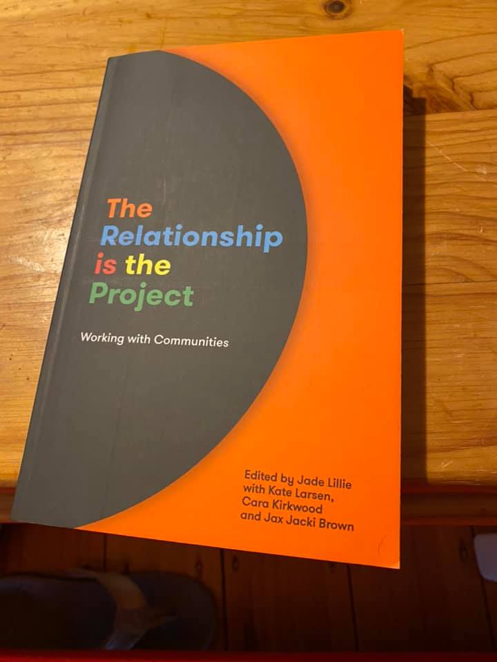 Image from the cover of the book The Relationship is the Project. The book is on a wooden table.